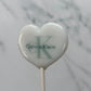 Heart-shaped lollipop with Calvin Klein logo on a marble background